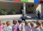 Przedszkolaki przyglądają się pokazowi psa służbowego 
