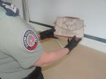 Funkcjonariuszka SCS trzyma w rekach torebkę ze skóry węża. Na przedniej stronie torebki widać głowę wężą